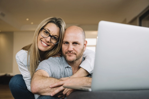 A happy couple in front of a laptop